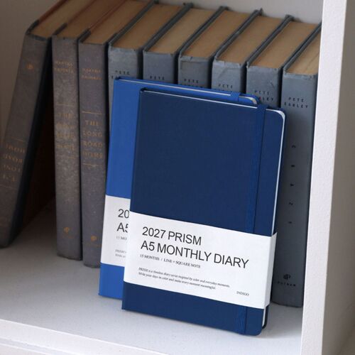 A white elastic band is stretched across the open Cloud cover, showing how the closure keeps the book together.