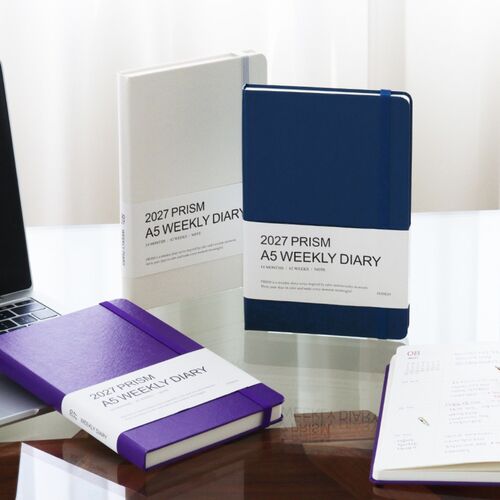 Cloud and Classic Blue planners stand upright while Sunset Purple rests nearby, highlighting the range of cover choices.