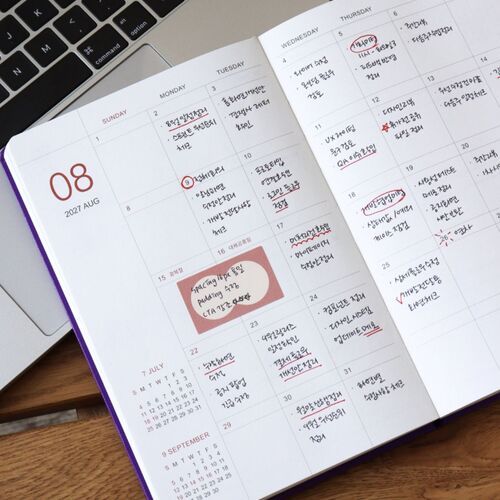 A decorated weekly page combines structured date boxes with stickers, colorful marks, and handwritten reminders.
