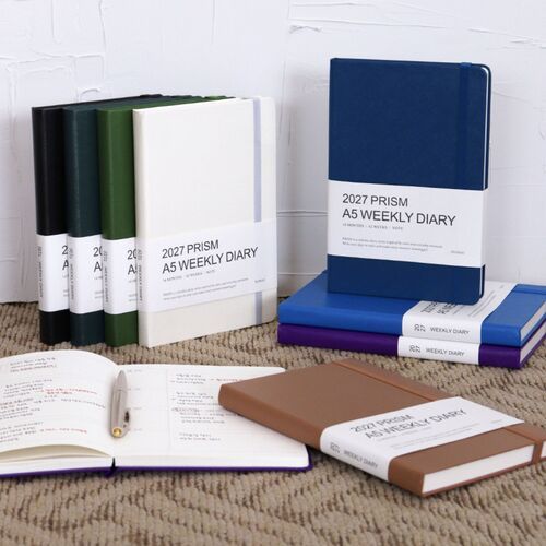 A purple planner is held at an angle, displaying the white bellyband and clean rounded cover corners.