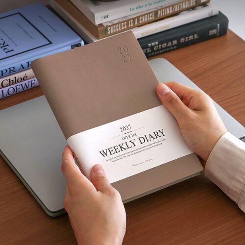 An open scheduler displays dated daily sections filled with notes, lists, and small hand-drawn accents.