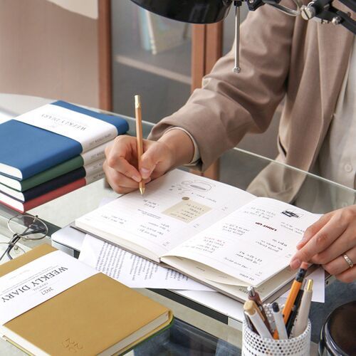 The planner is held inside a bag, showing how easily the slim book format travels between locations.