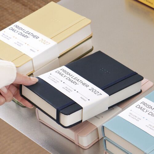 The Butter Mellow cover is held above its paper belly band, showing the embossed year and neatly rounded edges.