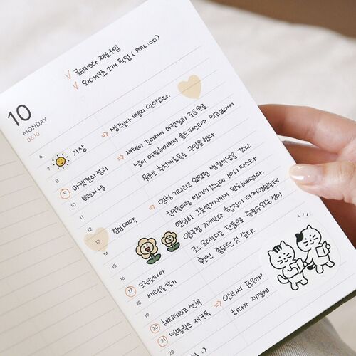 The open planner lies across a knit surface, with a blank lined page visible beside a decorated section.