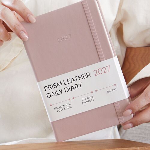 Butter Mellow sits on a wooden surface beside Green Mellow, with the belly band identifying the 2027 daily diary.