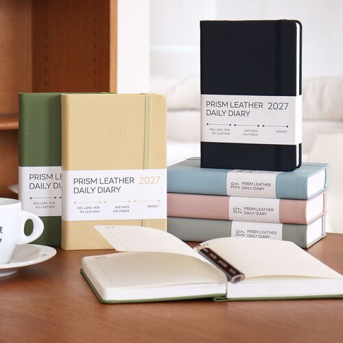 An open planner, pen, and coffee cup create a practical workspace view of the dated daily planning format.