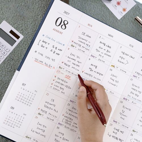 The August spread is shown at an angle with detailed handwriting, highlighting the generous width of each dated section.