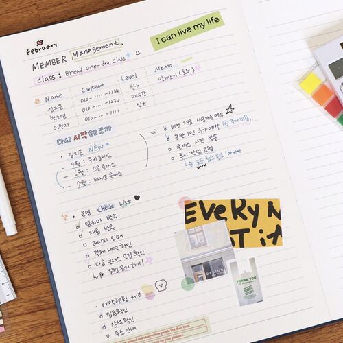Loose papers and cards are arranged across the open scheduler, showing the usefulness of its broad writing surface.