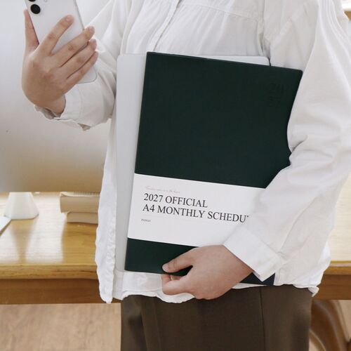 A person carries the Charcoal scheduler with a phone and laptop, illustrating its use alongside everyday work materials.