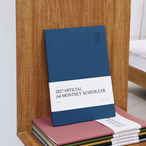 The Dark Green scheduler is held vertically with its title band visible, showing the understated professional cover design.
