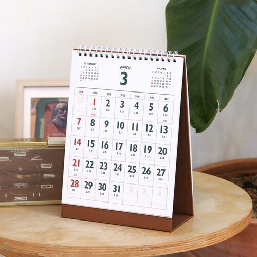 The March page stands on a wooden surface, showing large date numbers and ample boxes for appointments.