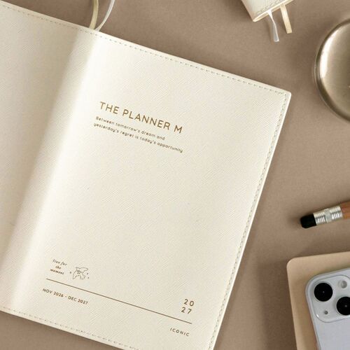 Milk White is shown close up with its textured cover, stitched edges, printed title, and dated November 2026–December 2027 format.