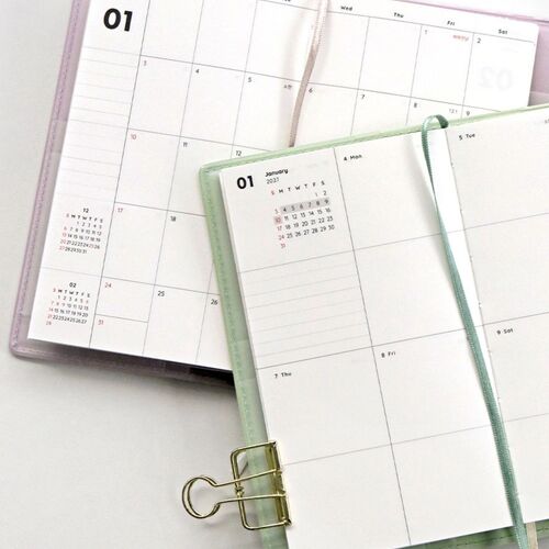 A hand turns through the Butter planner while holding a printed photo, demonstrating space for memory keeping.