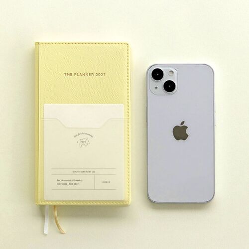 A hand lifts a card from the clear front pocket of the Butter planner, showing its practical storage space.