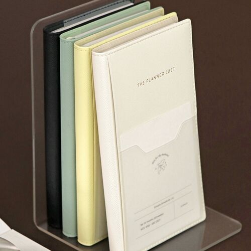 A side-by-side comparison shows the planner’s compact size next to a smartphone and several other planners.