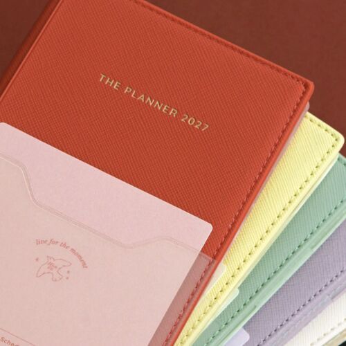 A close view of the open planner shows dated monthly boxes with space for appointments and notes.