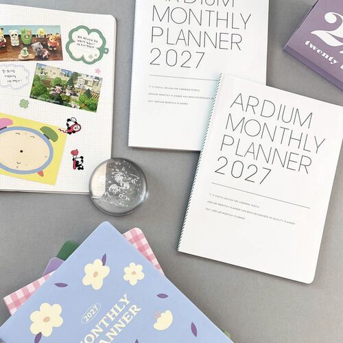 A stack of planners highlights the rounded corners, layered page edges, and different cover colors in one view.