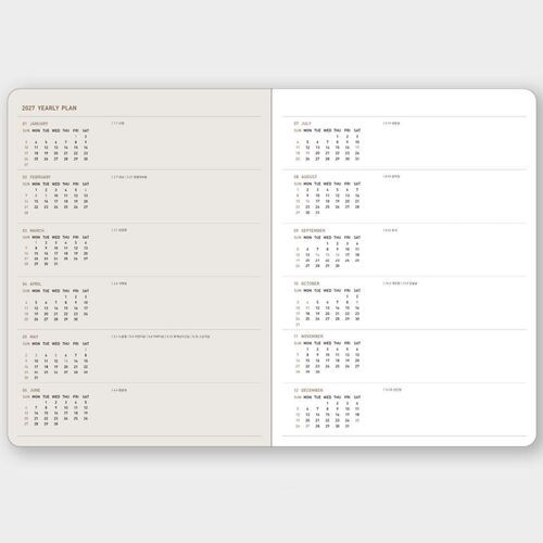 The planner is styled beside a keyboard and desk tools, placing the dated pages in an everyday work setting.