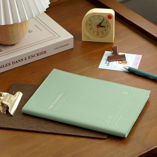 Mint is shown closed on a desk, highlighting its slim profile, stitched-looking border, and softly textured surface.