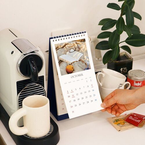 The Flower option stands beside a coffee setup, showing how the vertical calendar fits neatly into a daily countertop routine.