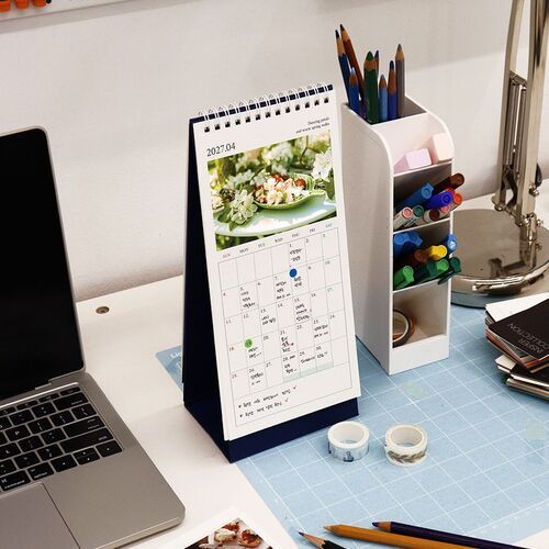 A close setting beside a laptop and stationery shows the navy Rainbow option positioned for convenient desk planning.
