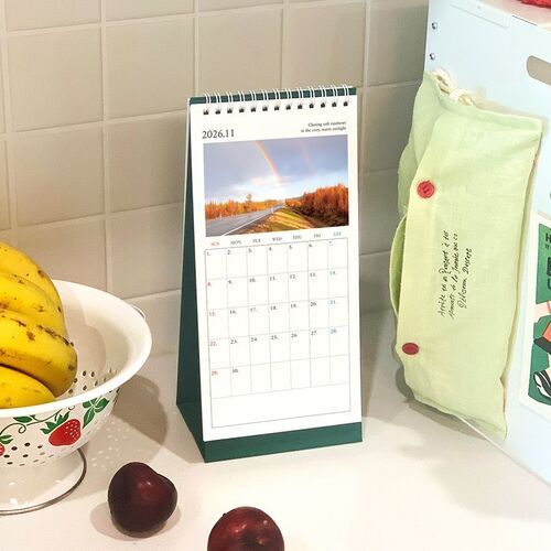 A desk view pairs the calendar with a laptop, pencils, and notes, highlighting the spacious grid for planning tasks.