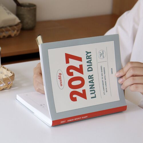 The Navy planner is held open to display the large 2027 cover design and clean framed layout.