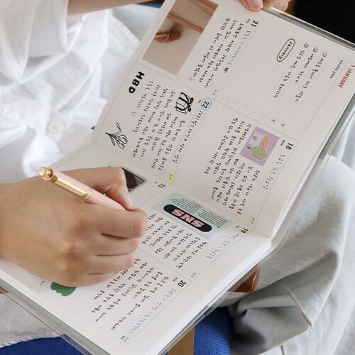 A close view shows dated weekly boxes with lunar dates, zodiac icons, colorful notes, and open writing space.