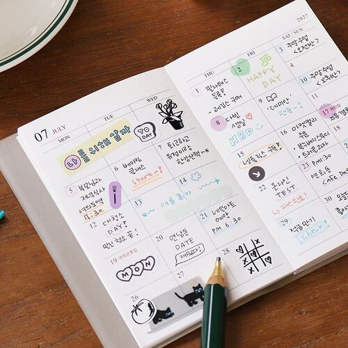 The July layout includes handwritten plans, small drawings, and colorful accents across its dated monthly boxes.