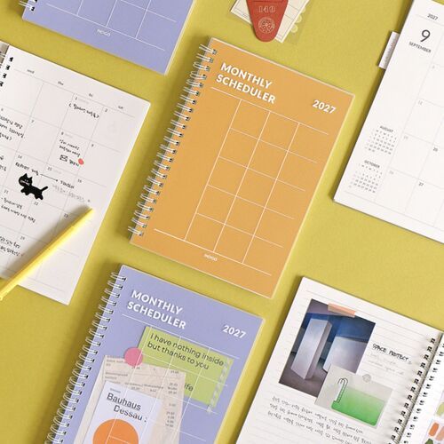 A close view highlights the Lavender cover beside the Orange style, with matching typography and white spiral coils.
