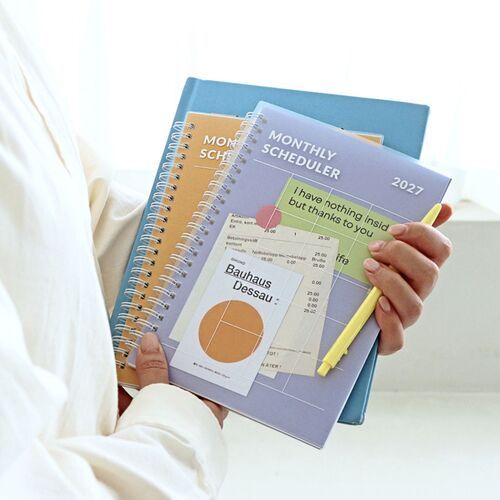 Several planners are held together to show the A5 scale, transparent cover edges, and white spiral construction.