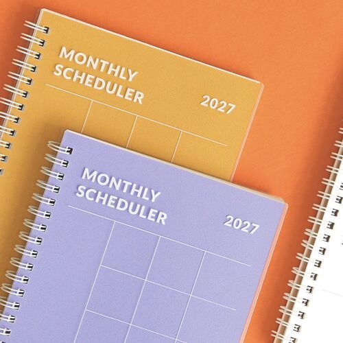 The Orange cover is shown in close detail with bold white lettering, the 2027 date, and a clean outlined grid.
