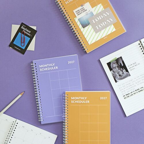 The planner is open beside photographs, color swatches, and notes, showing room for creative journaling and reference material.