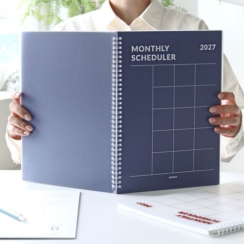 The Navy and White planners are held open to compare their covers and spacious monthly grid layouts.