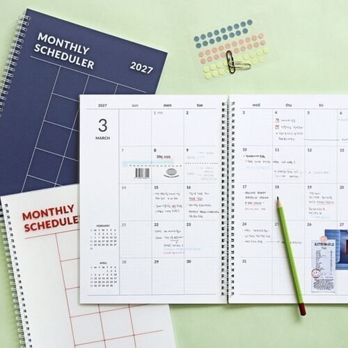 The White cover is held open to a lined notes page featuring a handwritten home baking plan and illustrations.