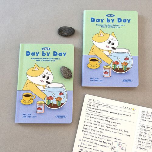 A close-up daily spread shows detailed handwritten entries, checklist marks, illustrations, and collage-style decorations across both pages.
