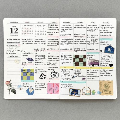 A close view of the Happy Puppies planner highlights its warm peach cover, rounded corners, paw-print details, and animal illustration.