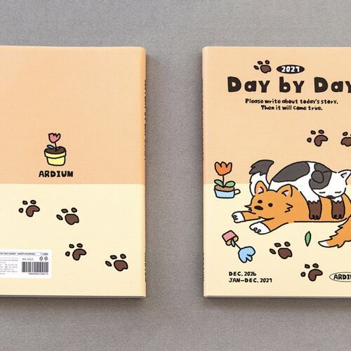 A peach Happy Puppies planner is shown beside its illustrated front cover, with the December 2026 and January through December 2027 dates visible.