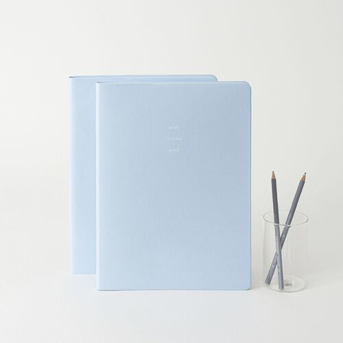 Ice Blue planners are displayed beside pencils, showing the wide cover format and understated centered typography.