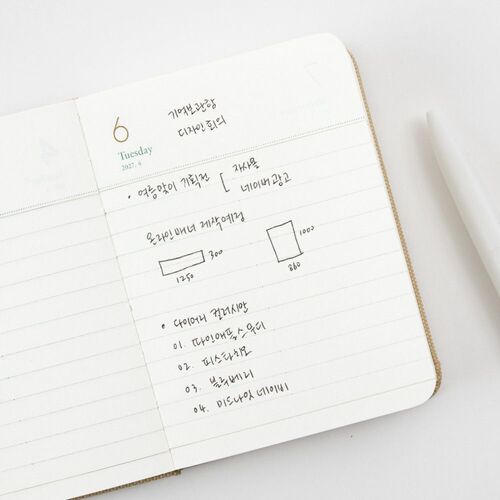 An open daily spread shows dated writing lines with gold numerals and green accents for organized everyday notes.