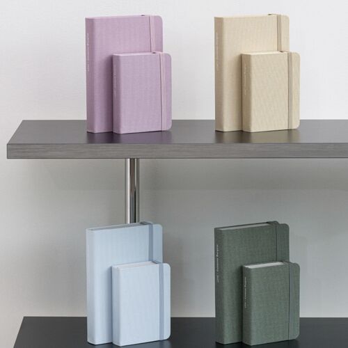 Muted Pink and Natural Beige planners are arranged in pairs on a dark shelf for a closer color comparison.
