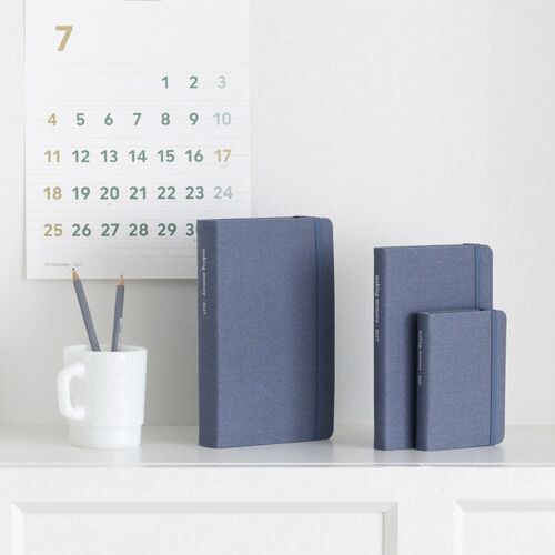 Natural Beige and Storm Gray planners are grouped in graduated sizes on a shelf display.