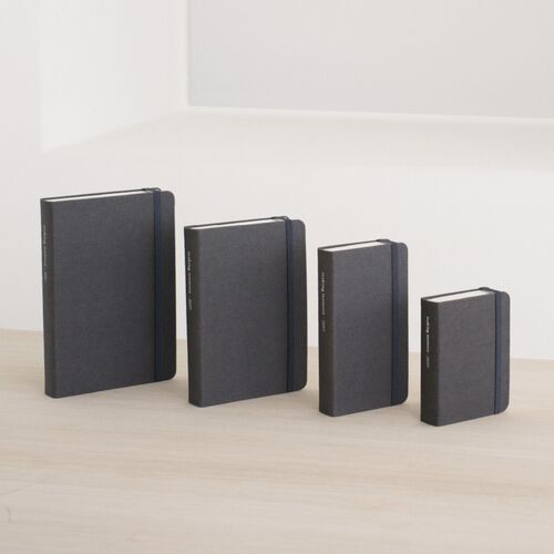 Modern Navy planners are stacked horizontally, showing their fabric-textured covers and elastic closures.
