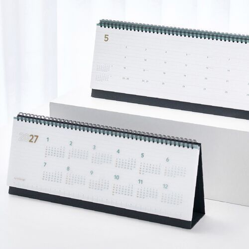 Two standing calendars display a full-year overview and a detailed weekly layout with black wire binding.