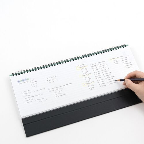 A close-up weekly layout shows dated columns, writing lines, and a sturdy black standing base below.