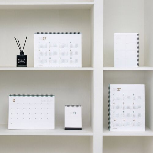 Displayed beside a pencil, the planner shows its mint spiral strip and lined pages designed for everyday notes.