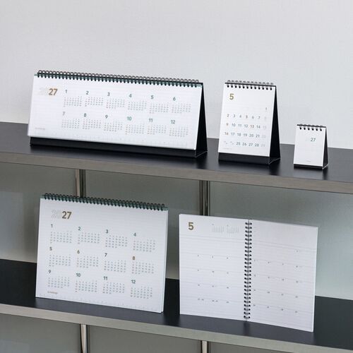 Several planner formats are arranged on shelves, making the medium spiral version easy to compare by layout and scale.