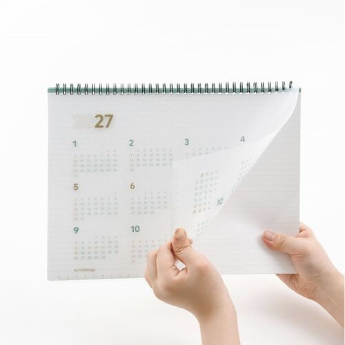 Hands lift a page to show the translucent PP cover and the planner’s clean, lightly ruled interior pages.