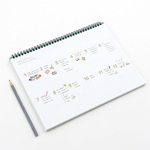 An angled view highlights the spiral binding, wide weekly writing area, and colorful monthly illustrations across the spread.