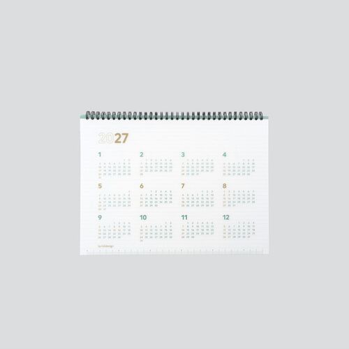 A straight-on view displays all twelve 2027 months with compact calendars and ruler markings along the lower cover edge.